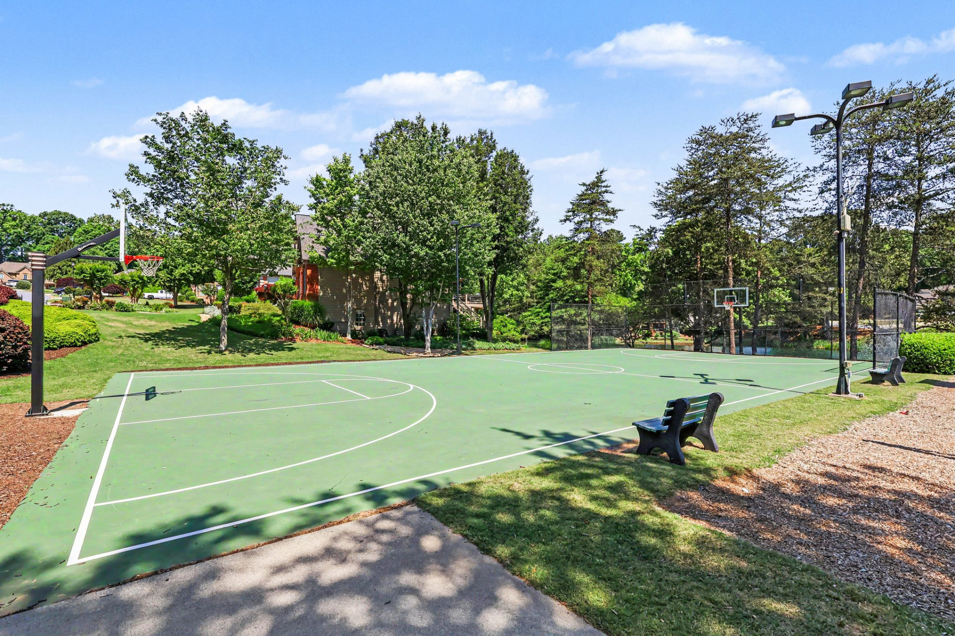 Full basketball court shaded by mature trees at Olde Atlanta Club