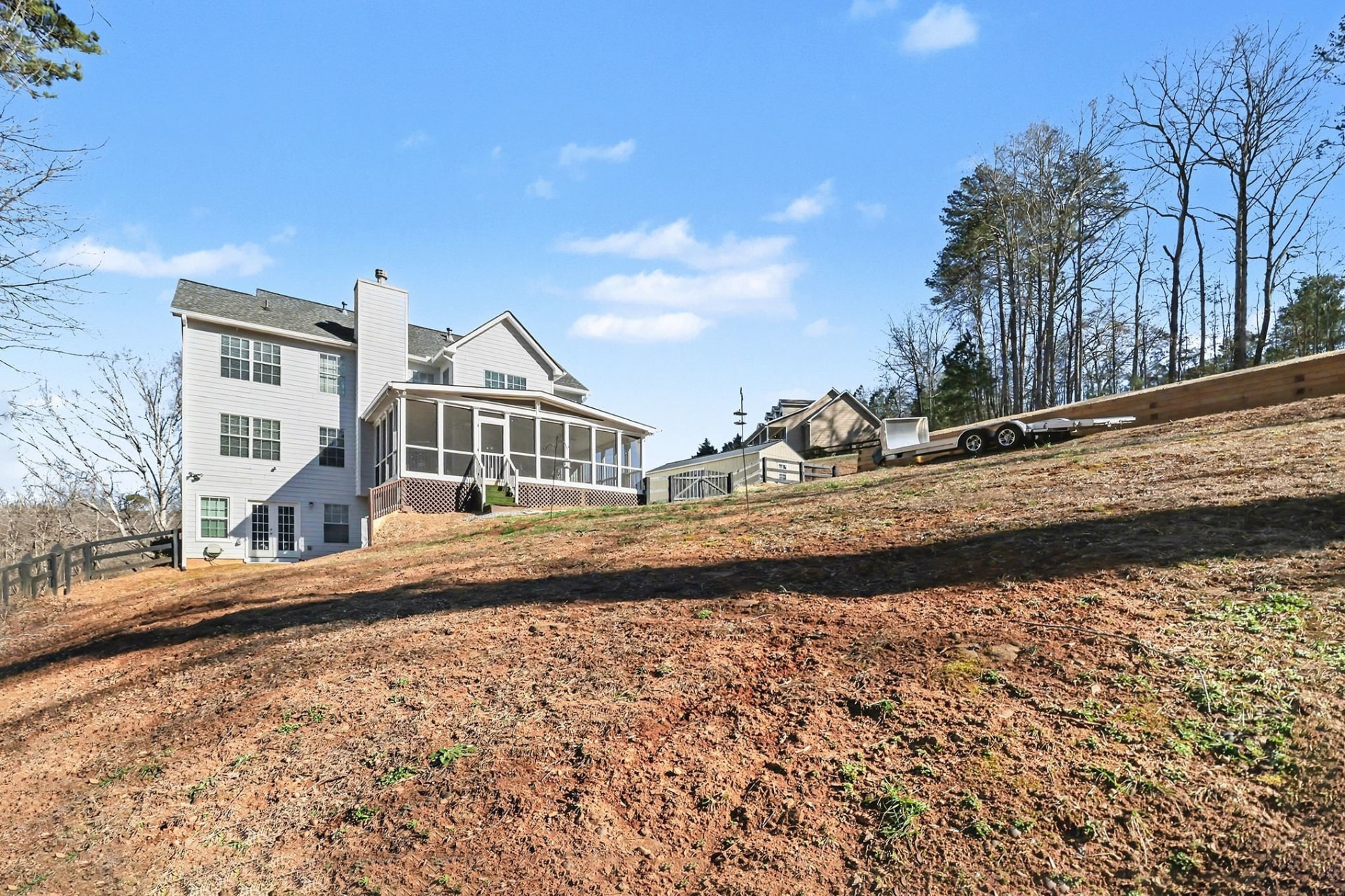 Rear elevation of the Cumming home with a screened porch and terrace-level entry