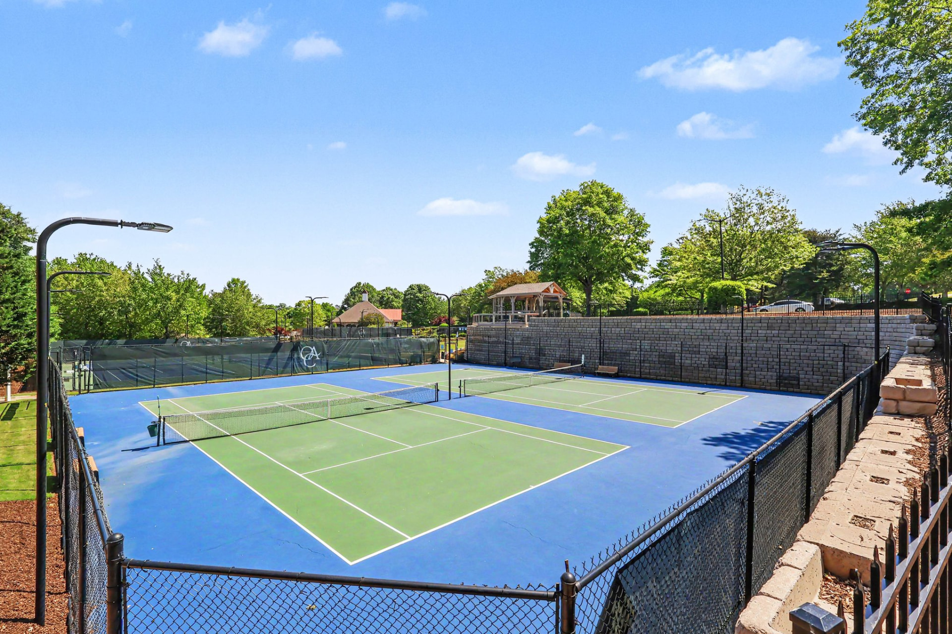 Lighted hard tennis courts marked with the Olde Atlanta Club monogram